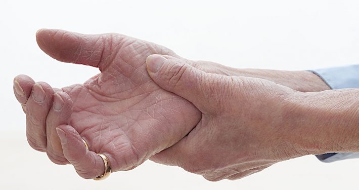 Old woman clutching sore arthritic hand