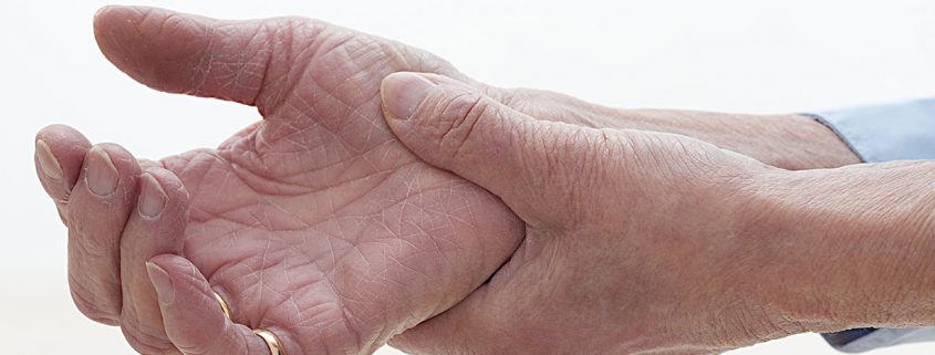 Old woman clutching sore arthritic hand