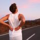 Runner grabbing his lower back with both hands, as if in pain