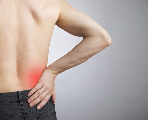 Man clutching painful area on lower back