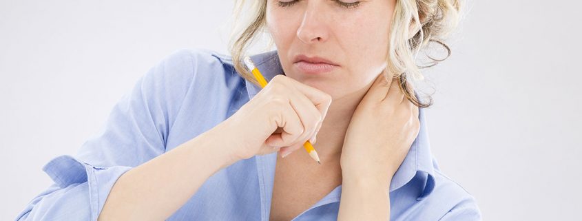 Woman scowling in pain and rubbing her neck