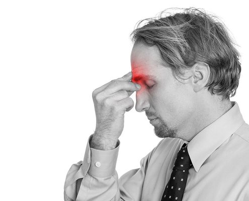 Man pinching the area between his eyes, as if his sinuses hurt