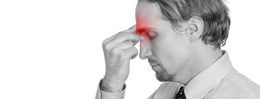 Man pinching the area between his eyes, as if his sinuses hurt