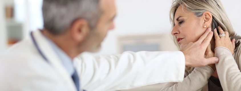 A woman showing her doctor where her neck pain is located