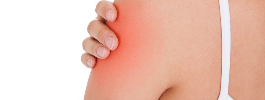 Close-up of a woman grasping her upper arm, a spot of pain highlighted in red