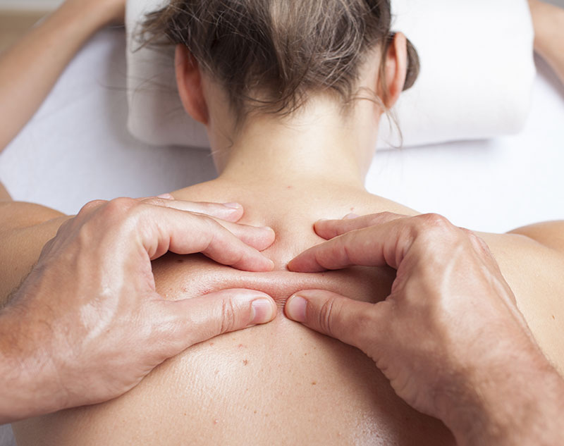 A woman receiving myofascial therapy on her back