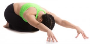 Woman in yoga gear in child's pose