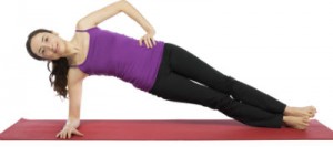 A woman in yoga gear, right elbow down, torso perpendicular to the floor, resting her weight on that elbow and right ankle