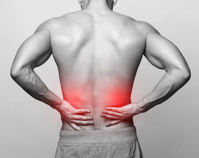 Close-up of a man with his hands on his lower back, red areas added to indicate pain