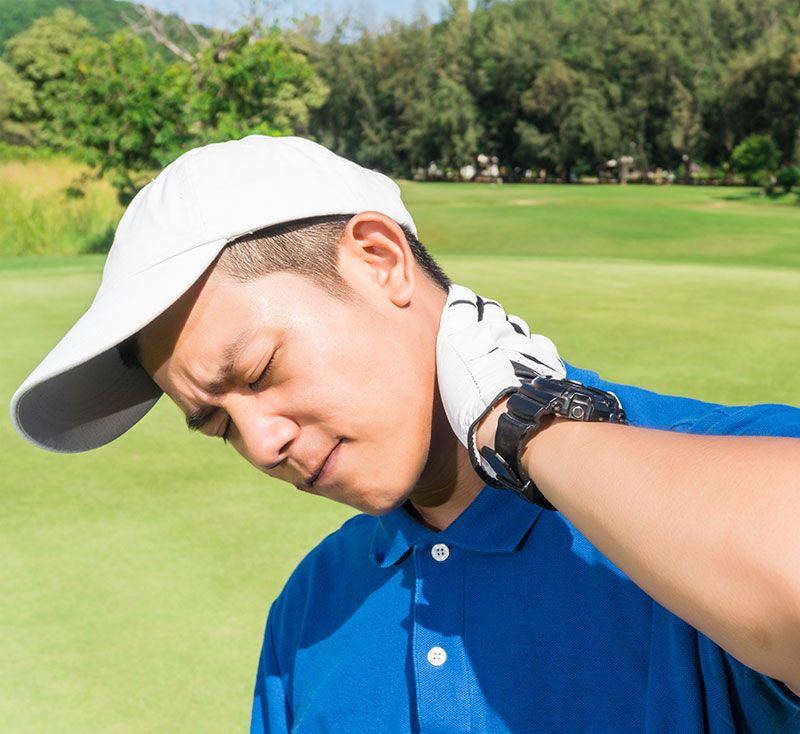Male Golfer with Neck Pain Male golfer scowling and clutching his neck in pain