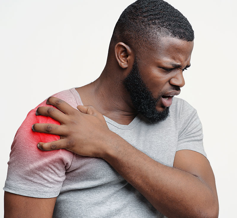 Young black male suffering from shoulder pain injury